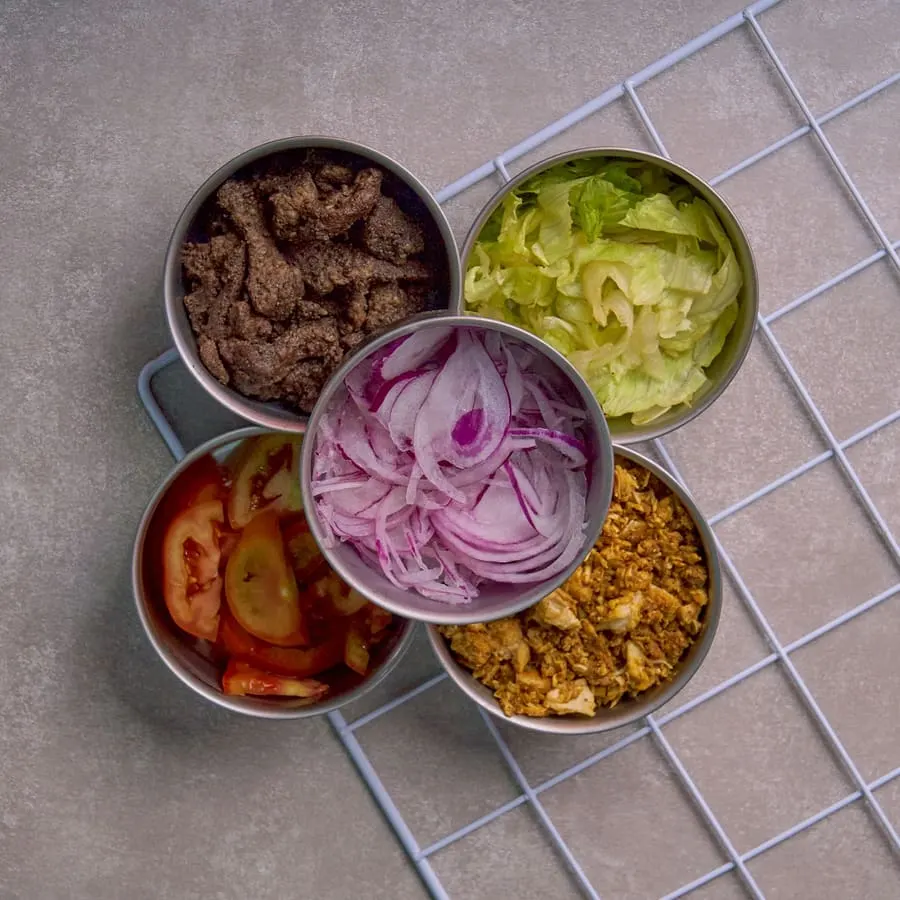 Kaplarda porsiyonlanmış taze sebze ve protein malzemeleri